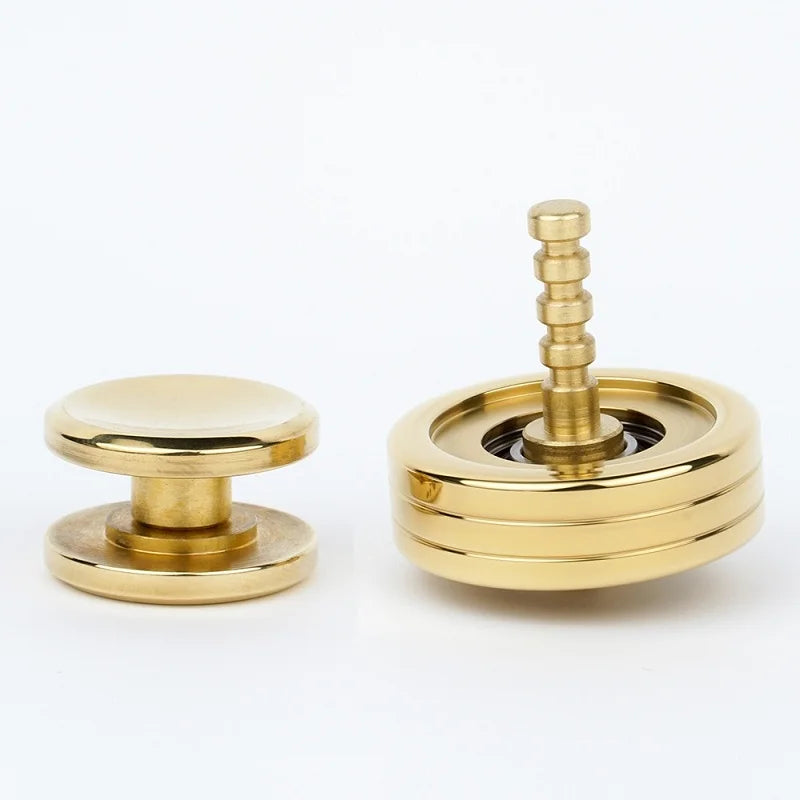 Two shiny gold metallic objects on a white background: one is a flat, round button-like piece; the other resembles the Creative Whirlwind Fidget Spinner, an innovative design with a central shaft and horizontal grooves, offering stress relief for both kids and adults.