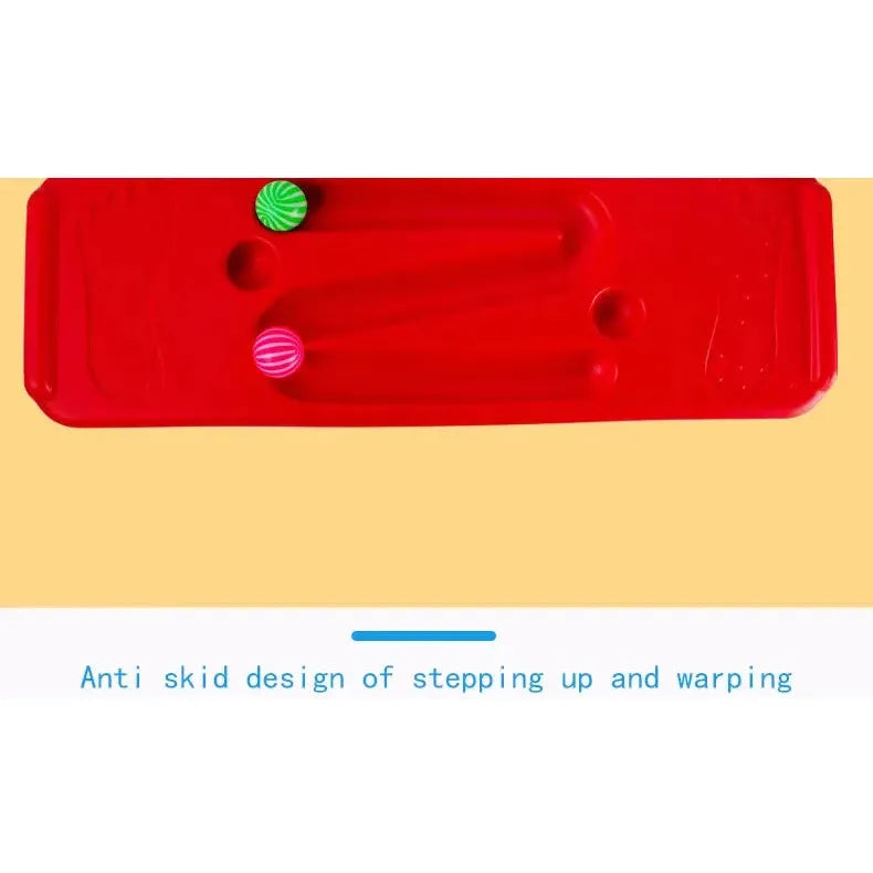 The Interactive Outdoor Balance Board Seesaw for Kids is a red toy with two grooves holding green and pink balls. Text on a yellow background reads, Anti skid design of stepping up and warping. Ideal for sensory training and balance exercises.