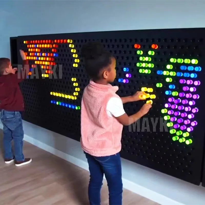 Two children play with the High Quality Snoezelen Sensory Room Toy Light LED Acrylic Peg Board, placing colorful pegs to create glowing designs. This interactive sensory wall panel is perfect for kids with autism and any sensory room setup.