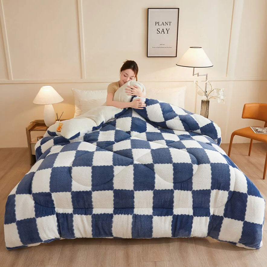 A person sits on a bed hugging a pillow in a cozy bedroom. The bed features the KDJEIKZ Ultra Cozy Winter Weighted Blanket, known for its luxurious milk velvet comforter, providing warmth and relaxation. The room is warmly lit with lamps, has a chair, and displays framed artwork on the wall.