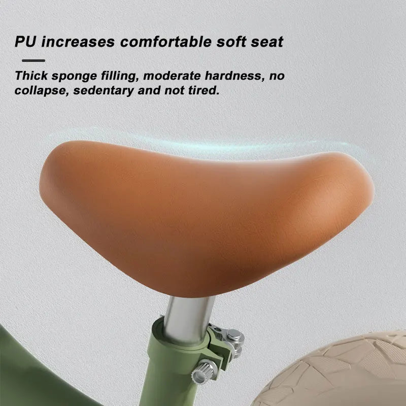 Close-up of a Magnesium Alloy Toddler Balance Bike - 12 Inch Wheels for Kids Age 3-12 featuring a tan padded seat with PU for comfort, thick sponge filling, and moderate hardness for no collapse and long rides. The bike has a green frame and silver seat post.