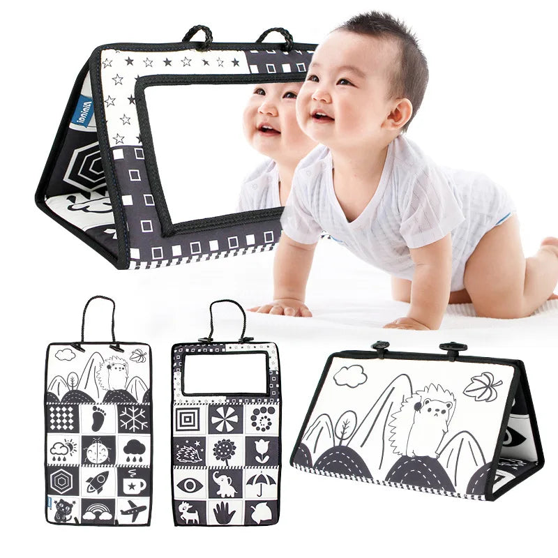 A baby crawls on the Crinkle Cloth Book Visual Stimulation Toy, a black-and-white mat with a mirror, ideal for sensory exploration. It showcases animal and shape patterns to boost visual development, with images of both front and back views.