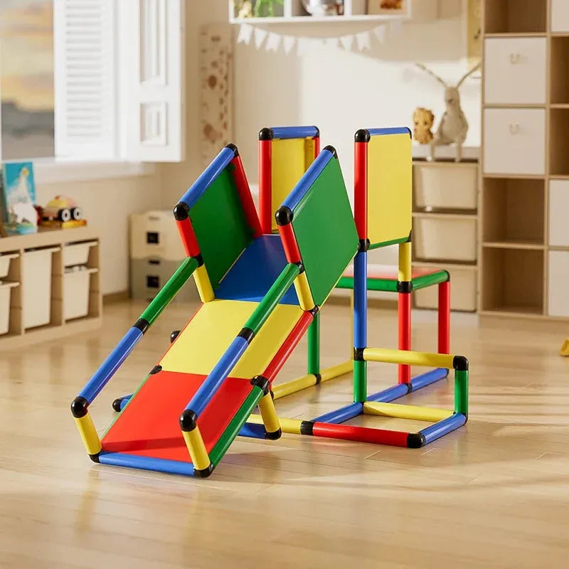 The Indoor Climbing Frame Set for Kids includes a vibrant baby slide and climbing frames in red, blue, yellow, and green panels. Located in a sunlit playroom with wooden floors and shelves, its ideal for sensory integration training.