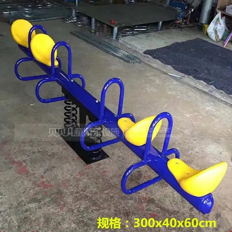 A vibrant seesaw with blue handles and bright yellow seats features a sturdy metal base and a spring for balance, perfect for outdoor use. It measures 300x40x60cm with the text in yellow at the bottom. Crafted as part of the Outdoor Steel Climbing Frame Swing for childrens sensory training.
