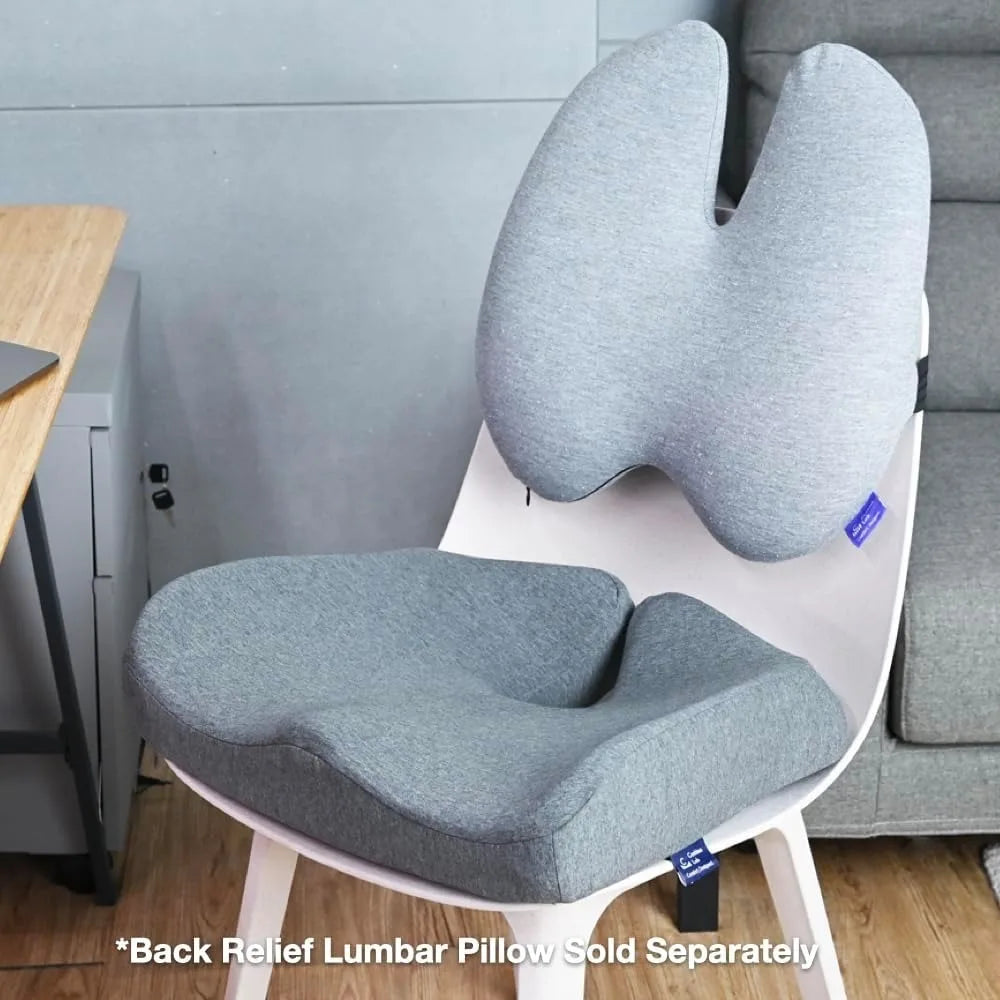 A white chair with a contoured gray Cushion Lab Pressure Relief seat cushion and matching backrest cushion for lumbar support sits by a desk. Text on the image states, *Back Relief Lumbar Pillow Sold Separately.