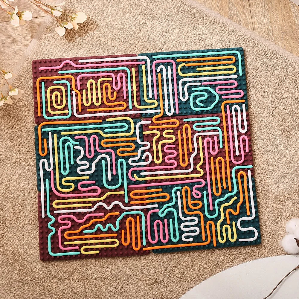 The Silicone Montessori Sensory Activity Board Fidget Toy for Kids features a colorful abstract maze with wavy paths in pink, yellow, orange, white, and turquoise on a brown base—perfect for anxiety relief and mindfulness.
