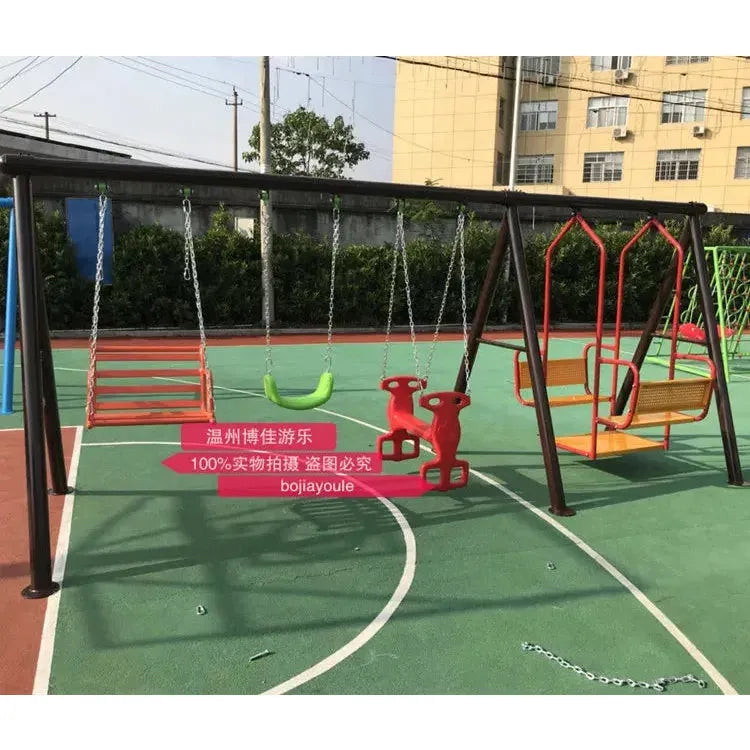 The unisex playground swing set, from the outdoor toys collection, includes a green seat, two red animal-shaped seats, and a yellow woven seat. Designed with durable metal for kids aged 3-8, it sits on a green surface encircled by a fence against a backdrop of buildings.