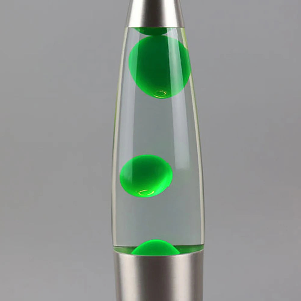 The Luminous Volcano Lava Jellyfish LED Night Light in silver features clear liquid with three evenly spaced green blobs inside its elongated glass vessel, creating a relaxing ambiance reminiscent of an LED night lights soothing glow against a plain gray background.