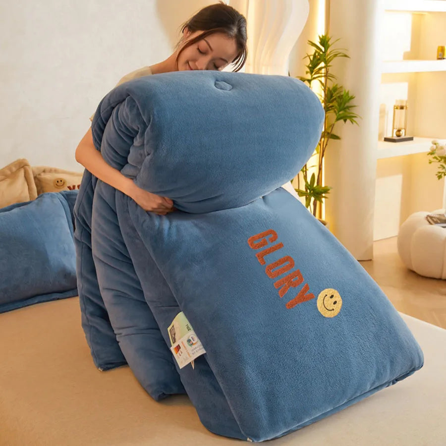 A person playfully hugs a large, plush cushion embroidered with GLORY and a smiley face. The blue cushion, featuring a luxurious milk velvet texture, feels soft and fluffy against the cozy rooms neutral tones.