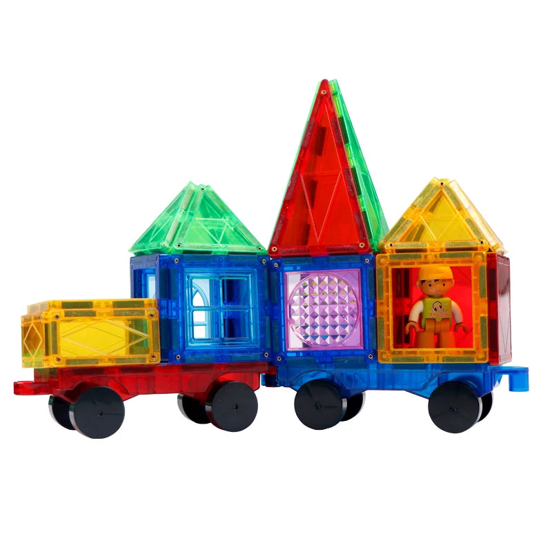 The Magplayer Magnetic Construction Blocks for Kids, an educational DIY set with transparent red, green, blue, and yellow geometric tiles like triangles and squares, promotes STEM learning. A toy train inspires imaginative play with a small figure in a yellow hat inside.