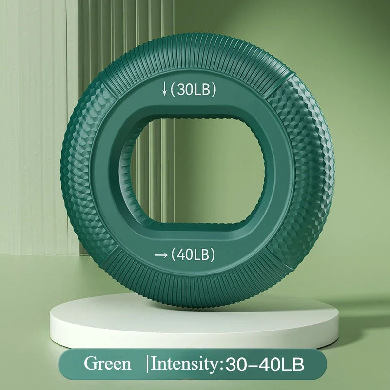 A green Silicone Grip Trainer Ring for Hand Strengthening and Wrist Rehabilitation with textured detailing sits on a white platform against a green background, showing intensity levels of 30LB and 40LB with arrows for different grip strength zones.