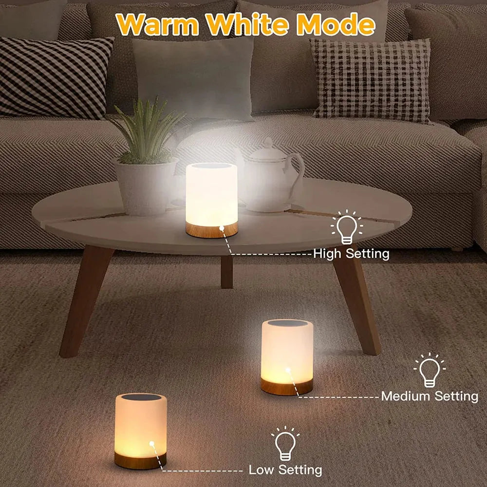 A cozy living room has a round wooden coffee table with a Portable Touch-Sensitive LED Night Light showcasing high, medium, and low settings. Warm White Mode text is above, set against beige sofa and checkered cushions.