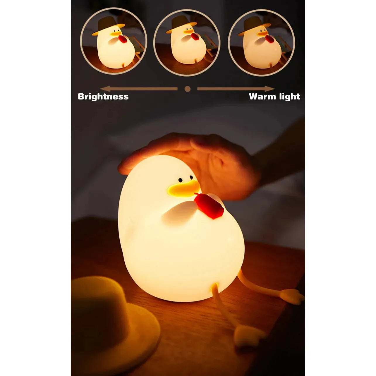 A person adjusts the Cute Cartoon Duck Rechargeable LED Night Light on a table, showcasing its warm light features. The silicone lamp has a yellow beak, red wattles, little feet, and a small hat nearby, enhancing the charm of this portable bedside night light for kids room decor.