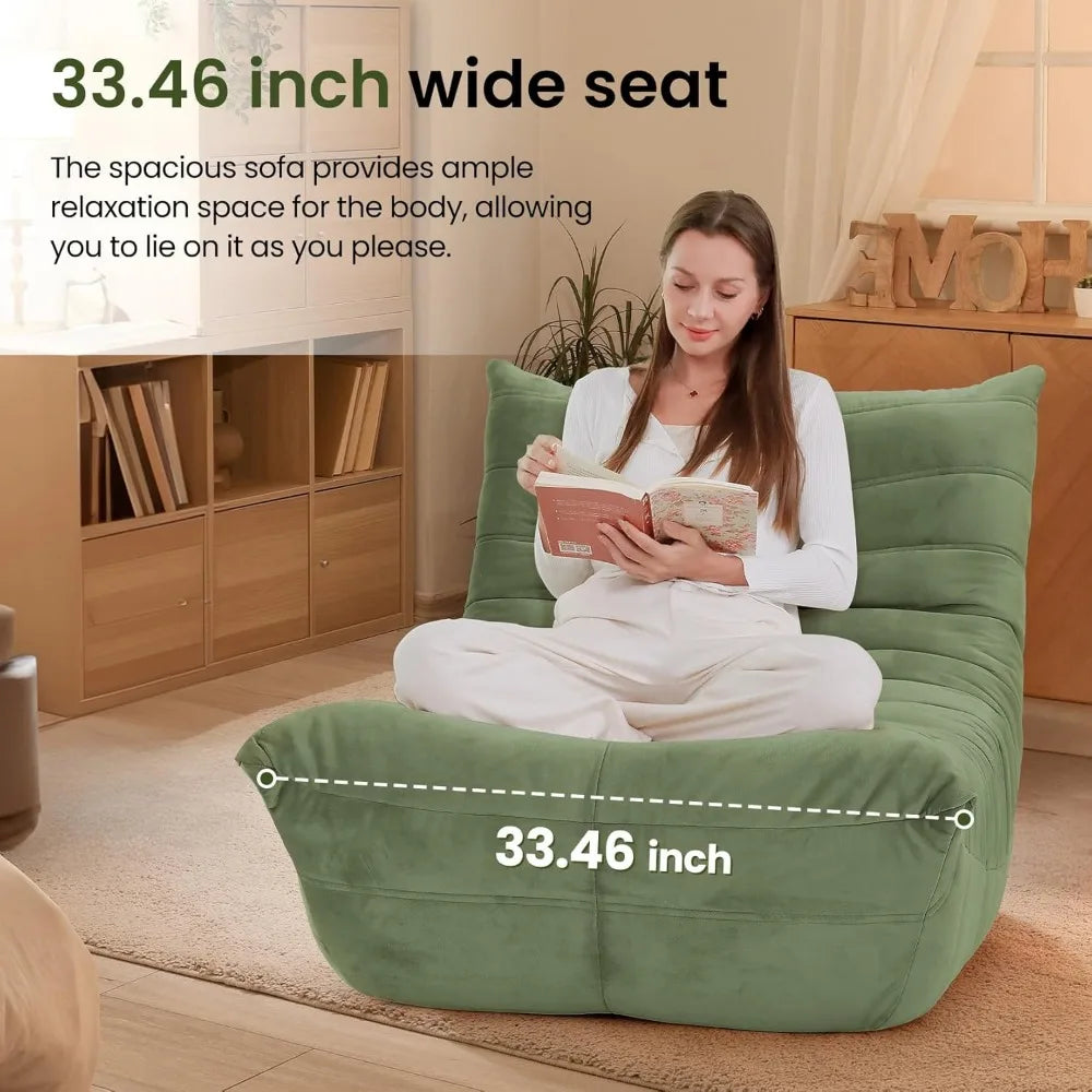 A woman sits cross-legged reading on the spacious Fireside Chair Bean Bag for Adults (33.46 wide), featuring soft suede fabric, in a cozy, sunlit room—perfect for ultimate relaxation.