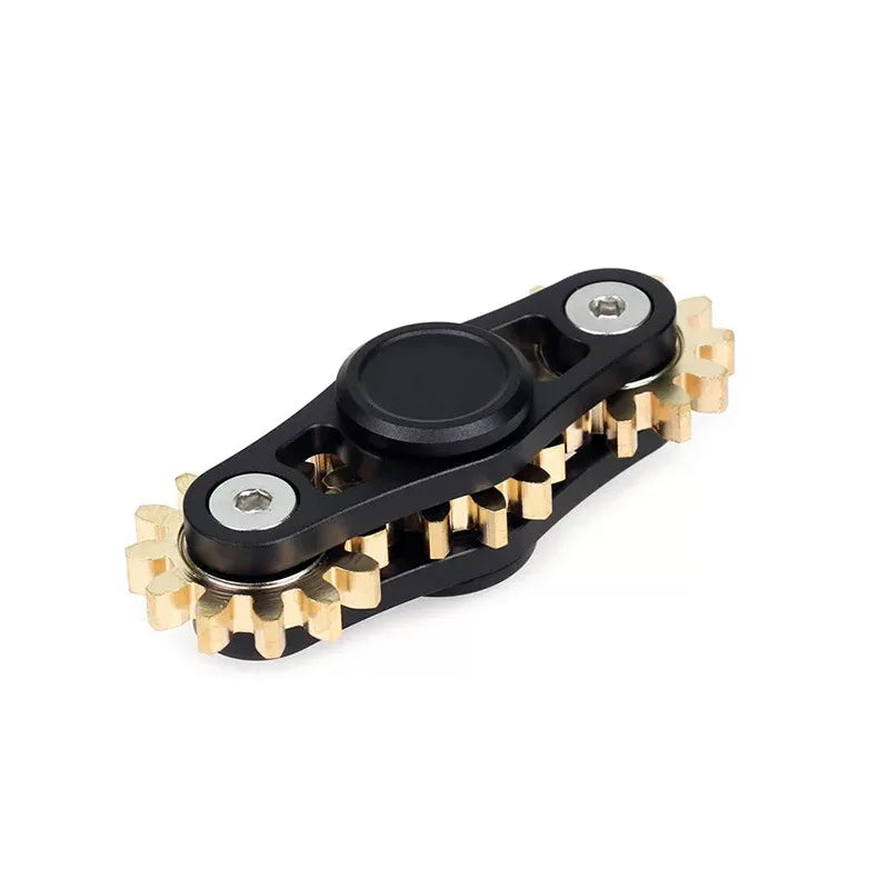 A black and gold Bike Chain Metal Fidget Spinner features nine gear linkage with magnetic slider, perfect for stress relief, lying on a white surface. The central part is black with a round button for holding.