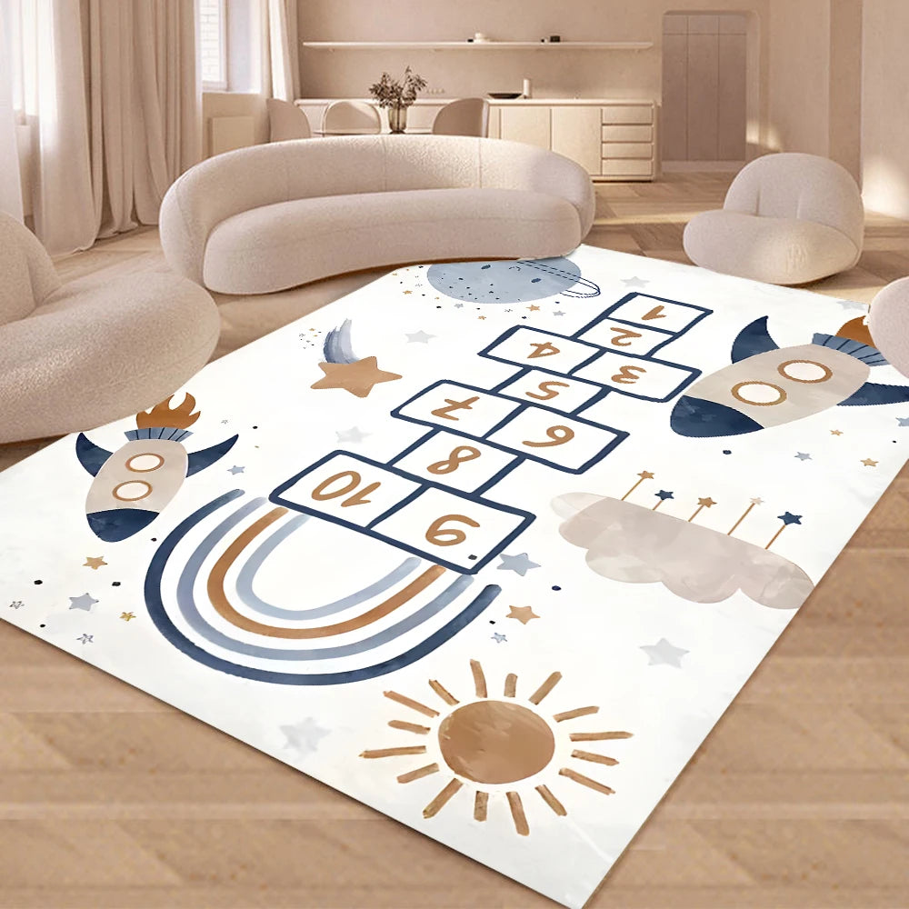 A modern living room features soft, curved furniture and the Hopscotch Printing Carpet, a washable, non-slip rug with playful designs like rockets, clouds, and stars in neutral and blue tones. Light streams through large windows.