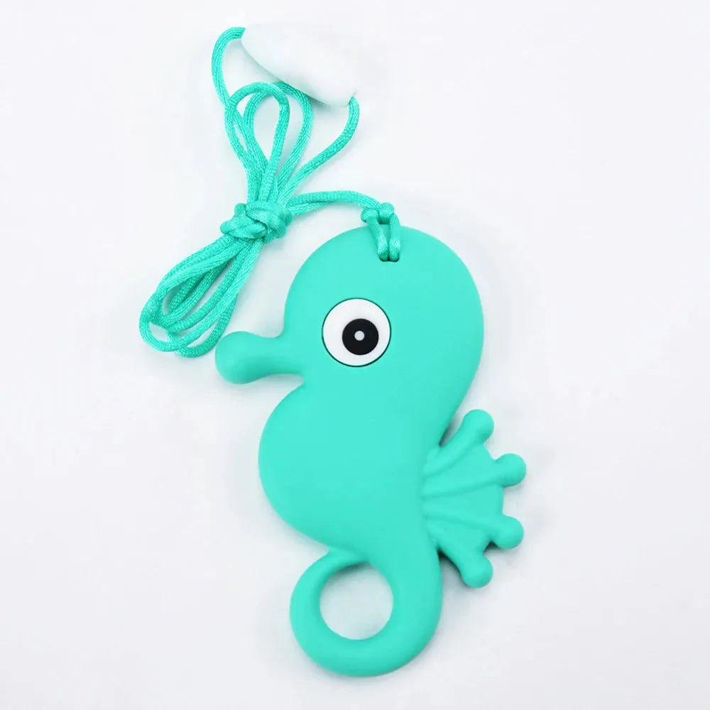 The Silicone Chewable Necklace for Kids is a practical and fun turquoise seahorse-shaped teether pendant with a cartoon eye and attached string, ideal for oral motor therapy in babies, especially benefiting those with autism or ADHD.