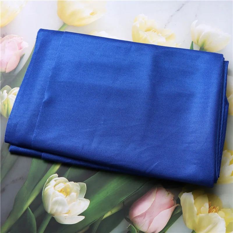 Folded blue fabric on a floral background with white and pink tulips sets a therapeutic mood, like the Extra-Large Sensory Swing Hammock for Kids and Adults with Special Needs - 59 x 110 for Sensory Integration.