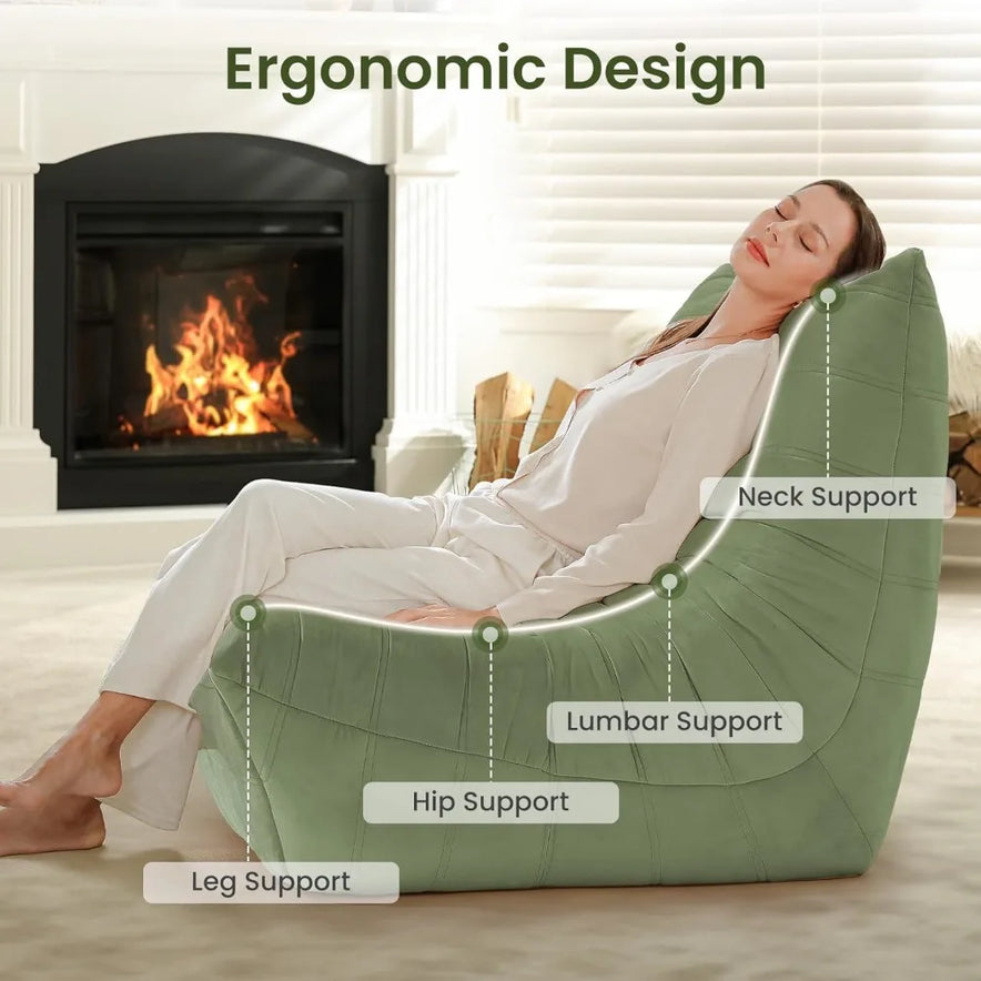 A woman relaxes on the Fireside Chair Bean Bag Chairs for Adults Big Lazy Sofa, enjoying ergonomic neck, lumbar, hip, and leg support from its memory foam fill in a bright, cozy living room by the fireplace.