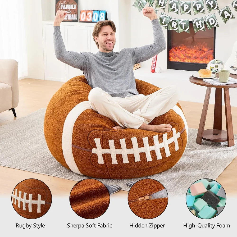 A man sits cross-legged, smiling and raising his arms on a Sports Football Bean Bag Chair for Adults and Kids made from ultra-soft Sherpa plush in a cozy living room with a birthday banner, digital clock, and fireplace. Four product features are shown below.