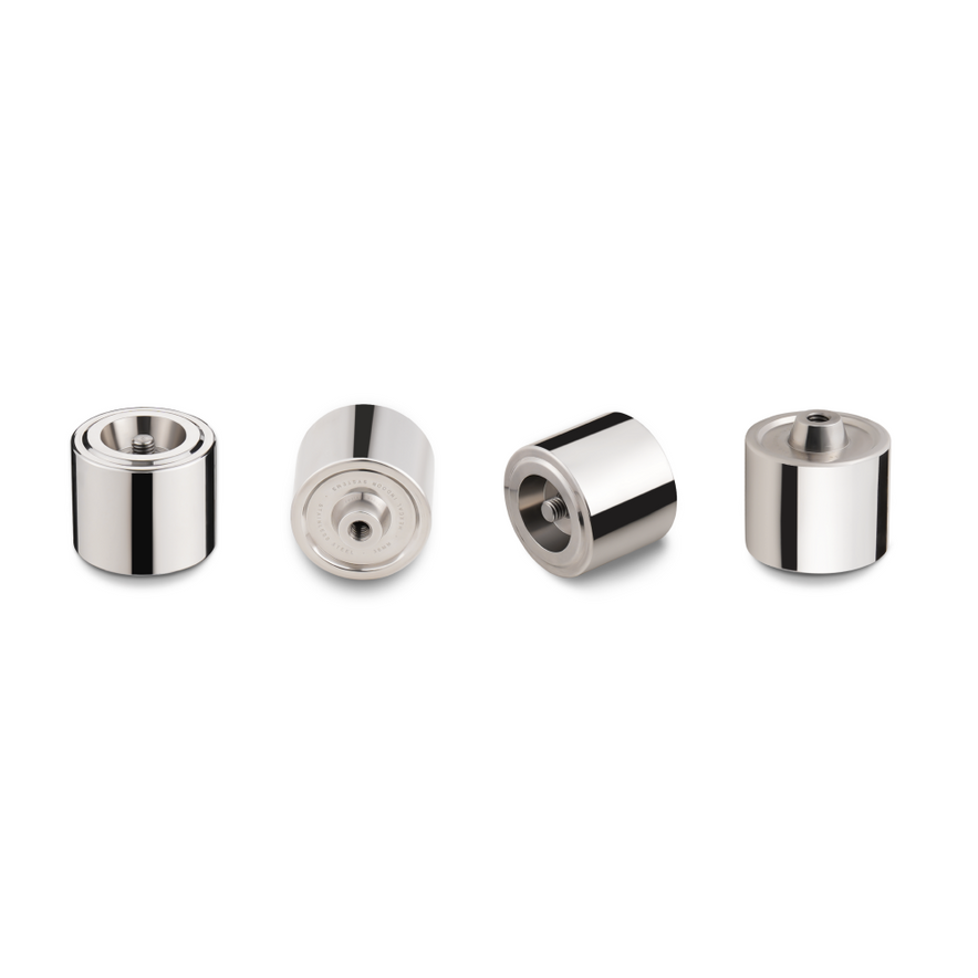 Four cylindrical metal components from the Hexcal Studio Extension Kit are shown in a row on a plain white background, each displayed from different angles to highlight their smooth, reflective surfaces and central openings.