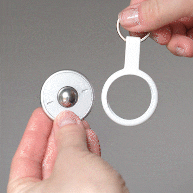 A person inserts a tracker into the ONO Scroller Keychain’s white silicone holder, showing how to use this convenient keychain accessory to keep the tracker secure and easily accessible for daily use.