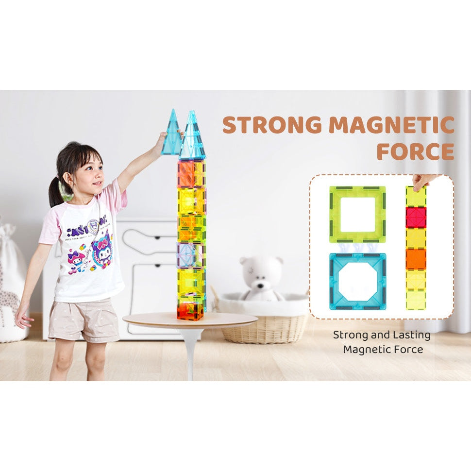 A child in a colorful shirt expertly builds a tall structure with the VEVOR 32PCS Colorful Magnetic Building Tiles Set on the table. In the background, a teddy bear sits on a chair. Text reads STRONG MAGNETIC FORCE emphasizing this durable STEM educational toy.
