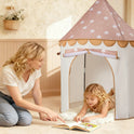 A woman points to a book while a young child lies inside a Starry Indoor Play Tent for Toddlers.