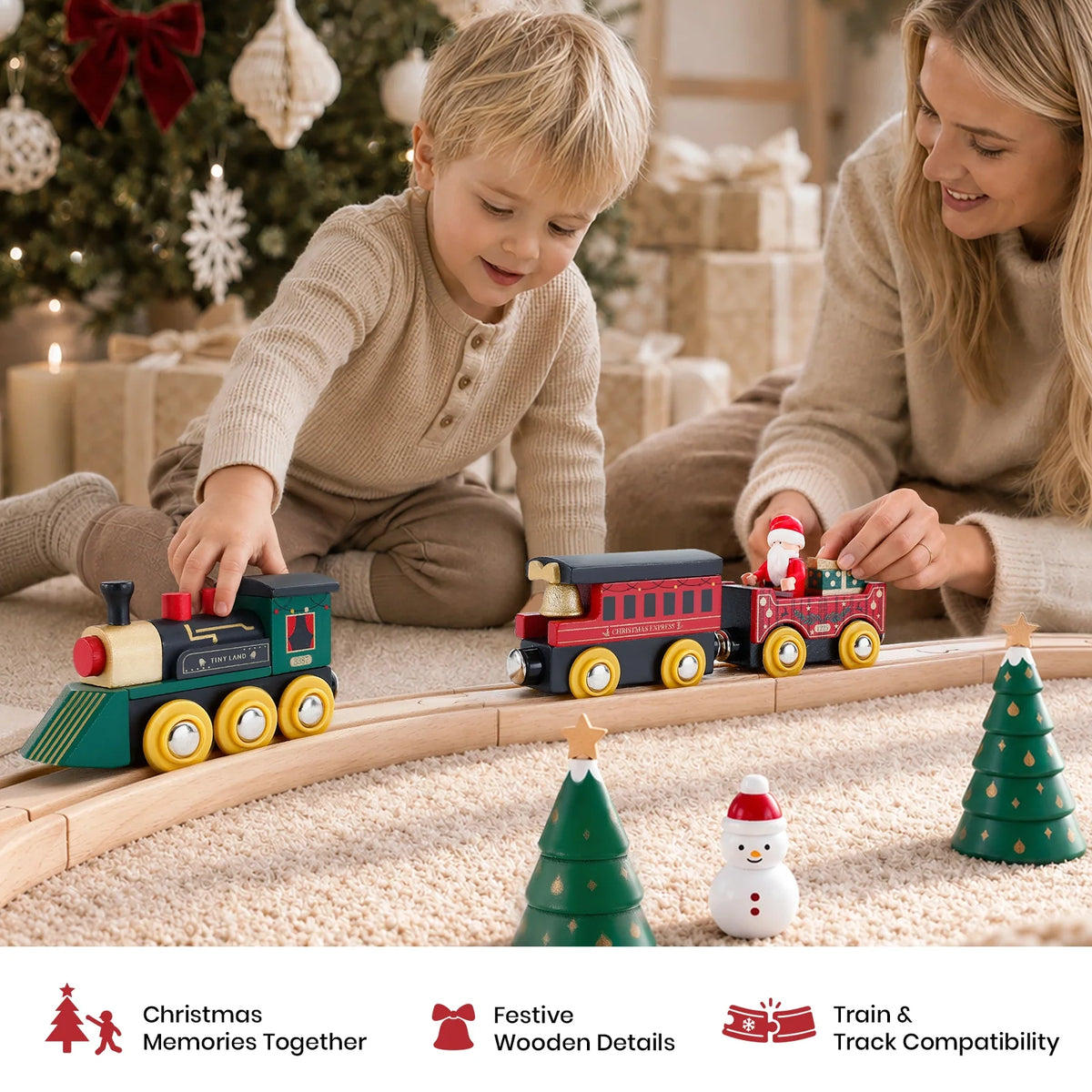 A woman and a young child play with a Christmas Express Wooden Train Set on a circular track within a Christmas village, surrounded by decorative wooden trees and a snowman.