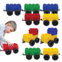 A young boy plays with Jumbo Building Blocks - 10 Car Kits - Bullet Train Set, featuring large red, yellow, green, and blue blocks with black wheels, arranged in rows on a white background.