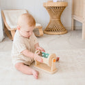 A baby enjoys the Tiny Land® Montessori Toys for Newborns (4–6 Months) on a light rug, developing fine motor skills in a softly lit, minimalist nursery with neutral-toned furniture.