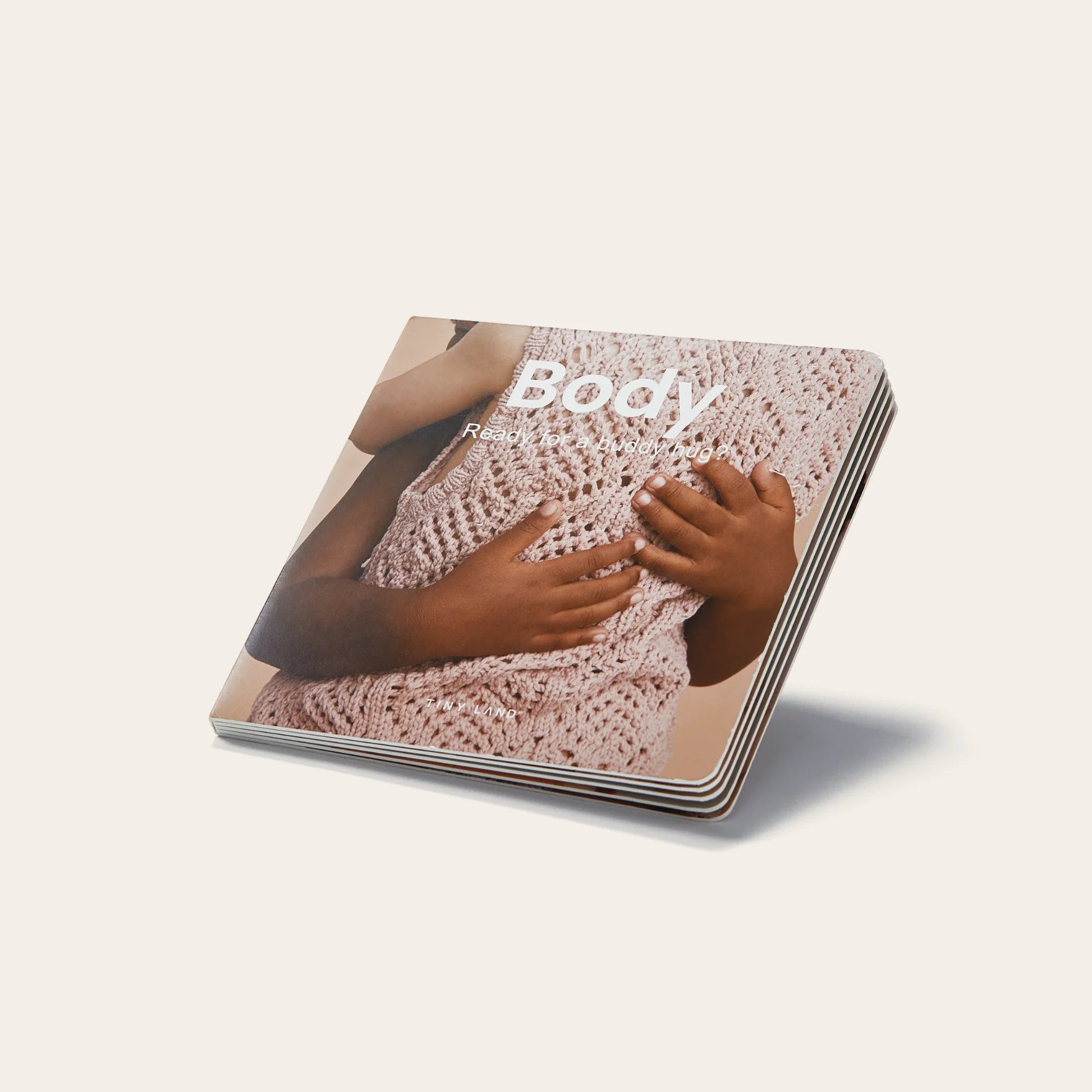 A children's board book titled Body shows close-up hands of two children with different skin tones touching an adult in a pink knit top, making it a perfect companion to Tiny Land® Montessori Toys for Newborns (7–9 Months).