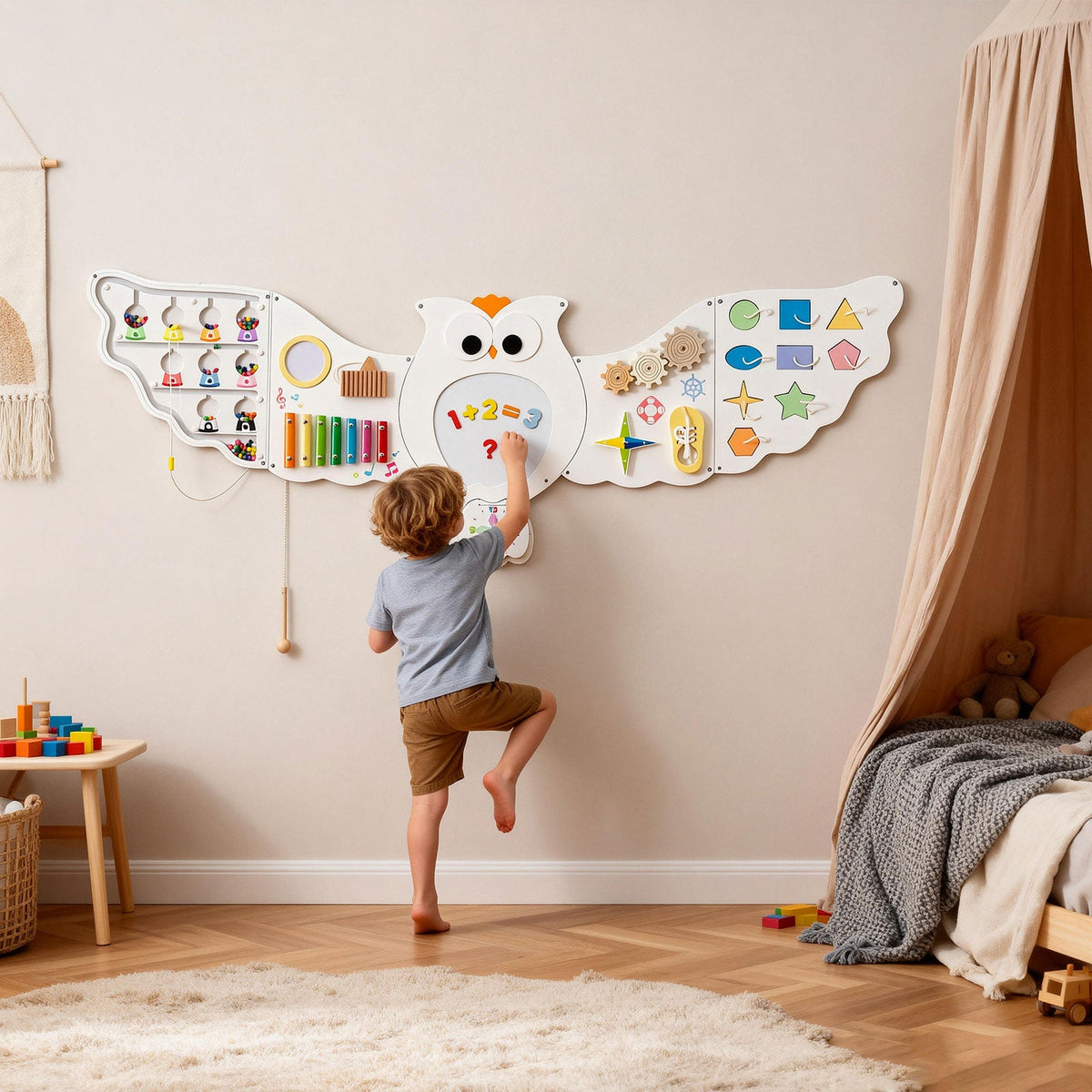 A child stands on one foot to reach an 11-in-1 Owl Wall Busy Board with Magnetic Math, featuring colorful gears, shapes, a xylophone, and a magnetic display.
