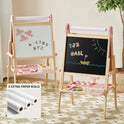 Two pink and wooden Magnitales Double-Sided Art Easel with Paper Roll units featuring a magnetic whiteboard side, a chalkboard side, and integrated storage trays, with three additional paper rolls shown in an inset.
