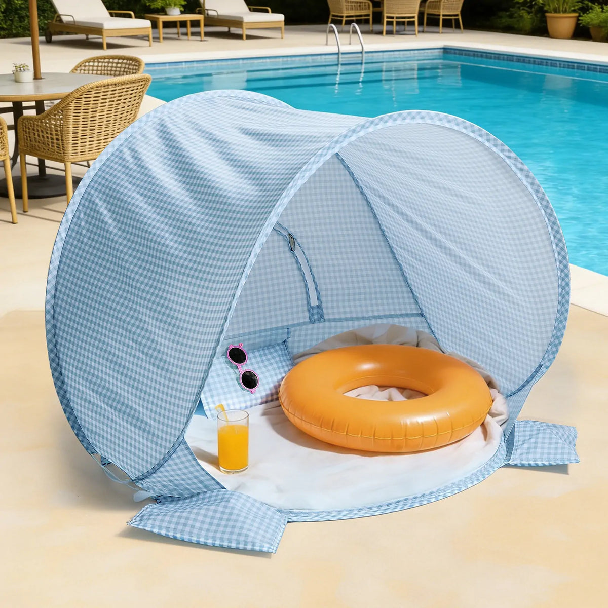 Kids Beach Tent & Sand Toy Set featuring a UV-protective blue and white gingham pop-up tent on a pool deck with an orange inner tube, a glass of orange juice, and pink sunglasses.