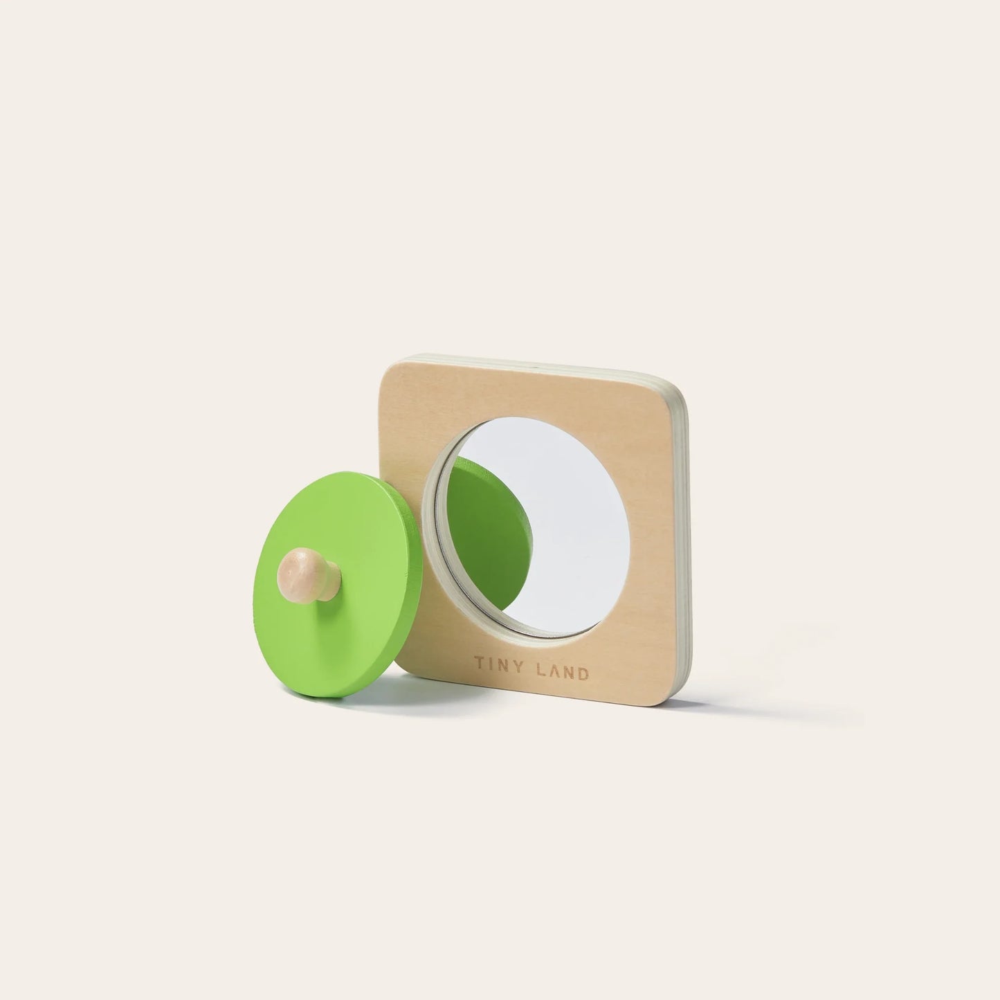 The Tiny Land® Montessori Toys for Newborns (7–9 Months) features a square wooden base with a round mirror and green knobbed circle—ideal for building object permanence skills.