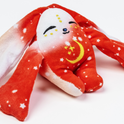 Rover Mini Wrist Hugger – Magnetic Sensory Plush rabbit toy with red and white star-patterned fabric, a crescent moon embroidered on its chest, and eyes closed in a peaceful expression; this pocket-sized comfort makes a perfect fidget toy.