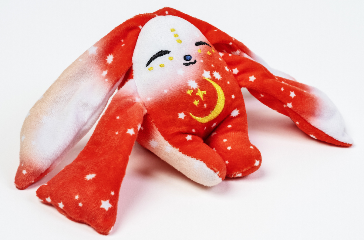 Rover Mini Wrist Hugger – Magnetic Sensory Plush rabbit toy with red and white star-patterned fabric, a crescent moon embroidered on its chest, and eyes closed in a peaceful expression; this pocket-sized comfort makes a perfect fidget toy.