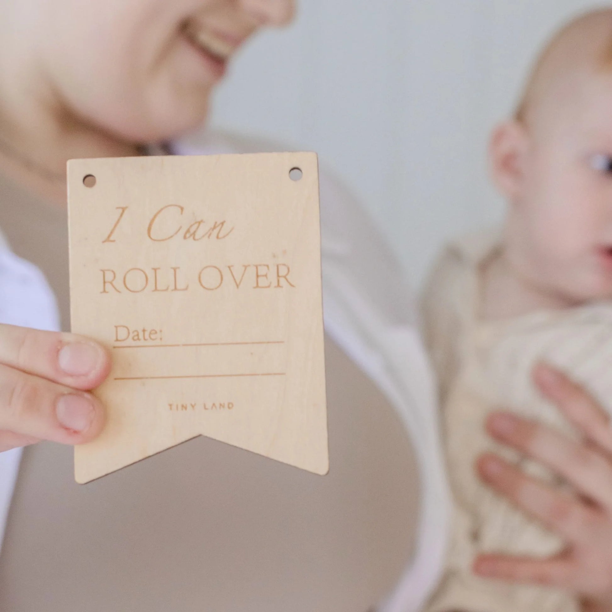 Celebrate milestones with a wooden "I Can Roll Over" sign (with space for a date) while holding your baby—perfect alongside Tiny Land® Montessori Toys for Newborns (4–6 Months) to encourage development.
