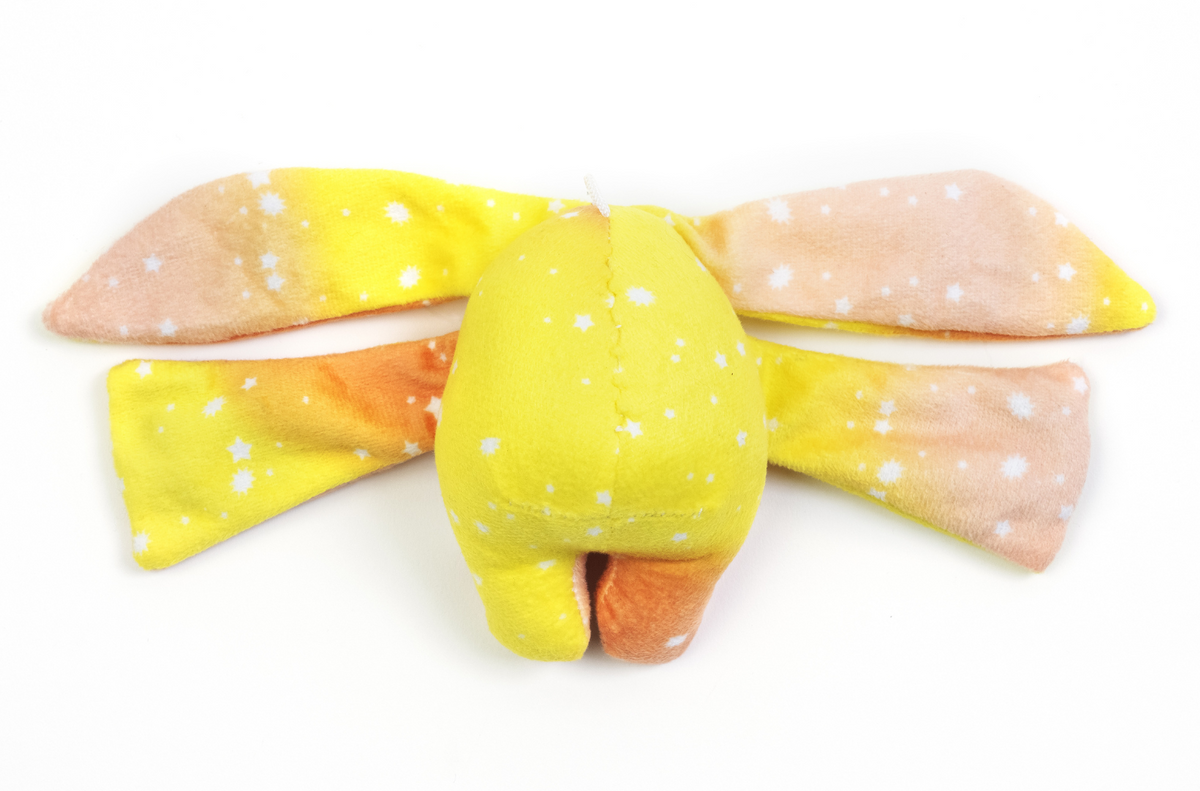 Rear view of the Spark Mini Wrist Hugger – Magnetic Sensory Plush, a yellow and orange toy with long, floppy ears and a star pattern designed for portable comfort.