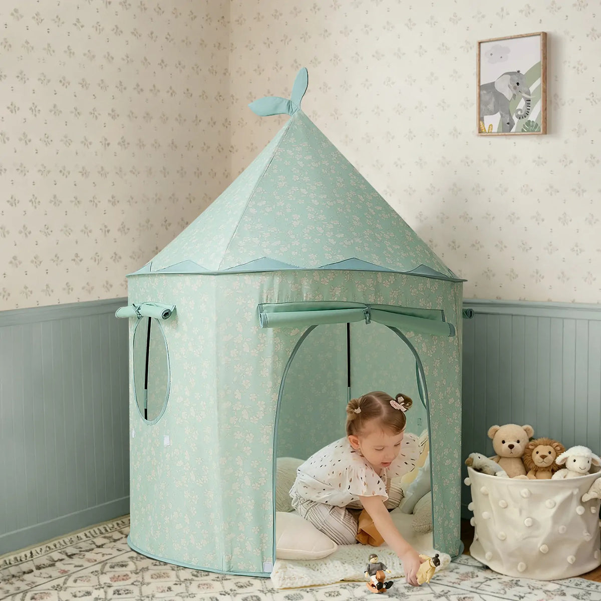 A young child plays with toys inside a light green, flower-patterned Starry Indoor Play Tent for Toddlers.
