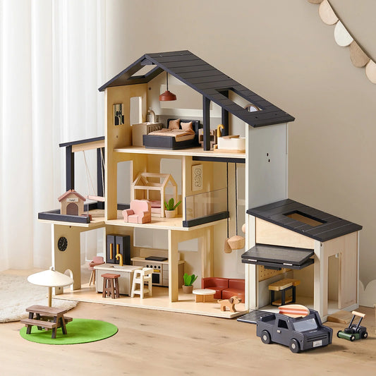 The Sweetwood Edge Dollhouse & Garage Bundle is a multi-story modern dollhouse featuring a wooden garage, miniature furniture, a toy car, and a picnic set.