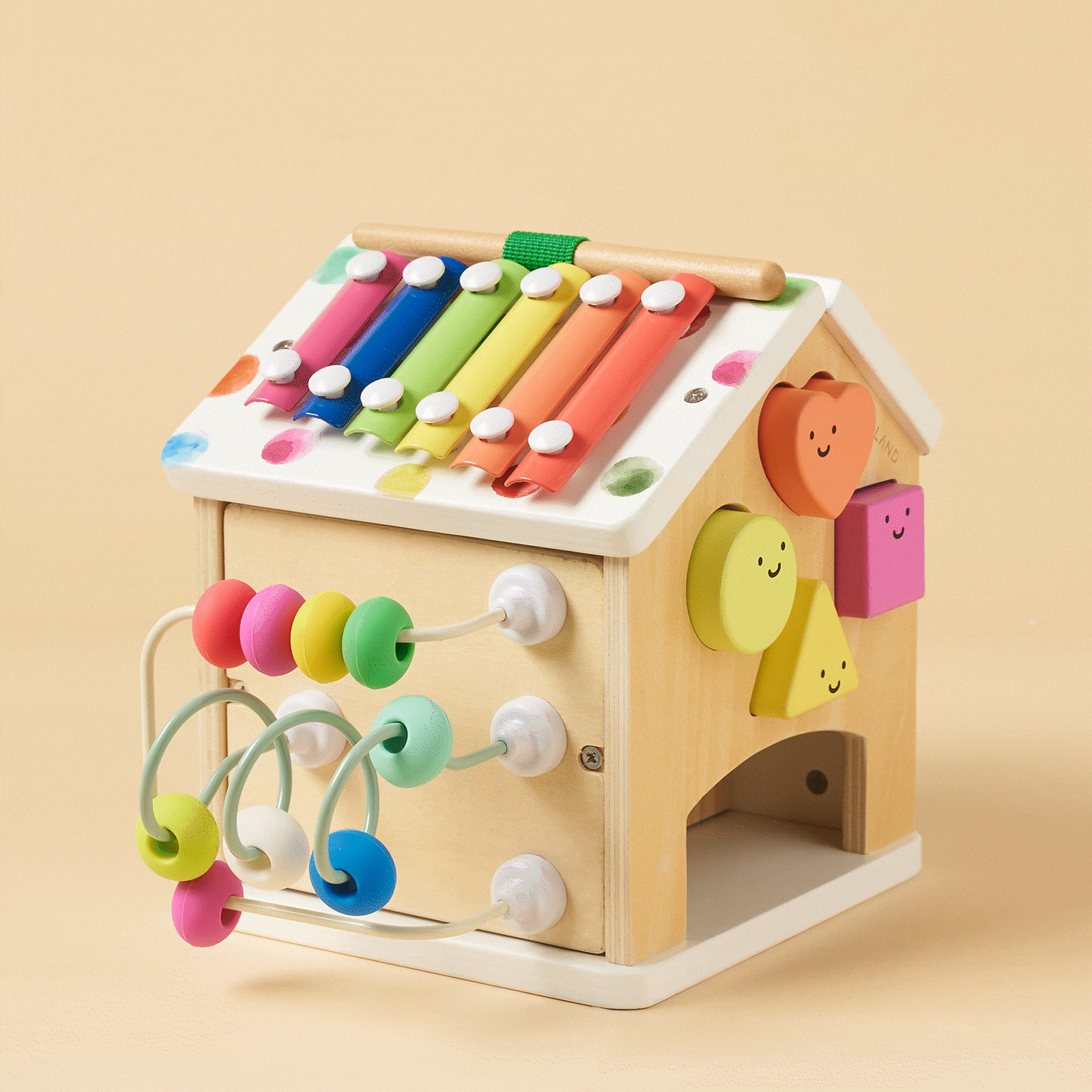 Montessori Cottage Activity Cube – Rainbow shaped like a wooden cottage, featuring a xylophone roof, a side bead maze, and colorful geometric shape-sorting pieces to build fine motor skills.