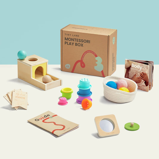 The Tiny Land® Montessori Toys for Newborns (7–9 Months) set includes wooden toys, stacking cups, a sensory ball in a basket, soft book, activity cards, guide booklet, and comes in a labeled box on a light surface.