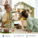 Two children play with a Sweetwood Cottage Dollhouse (48-pc Furniture), a multi-level wooden dollhouse furnished with 1:12 scale chairs, tables, beds, and a pet area.