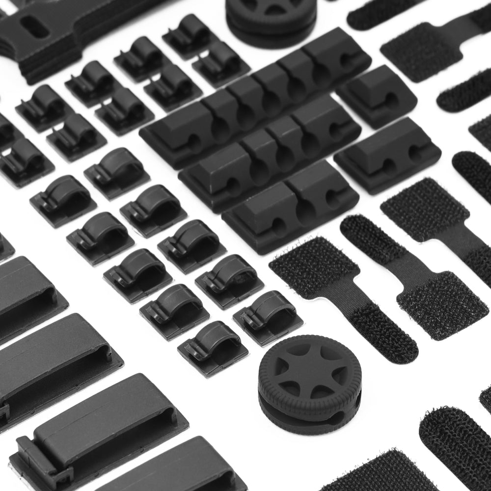 The Cable Management Kit features black plastic clips, fasteners, wheels, and hook-and-loop straps, all neatly arranged in rows on a white background for efficient cable organization.