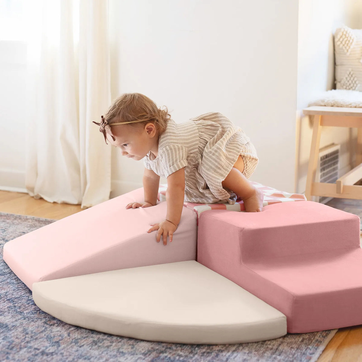 A toddler crawls over a PlayNest Soft Foam Climbing Blocks – Violet obstacle course made of soft violet and pink foam blocks.