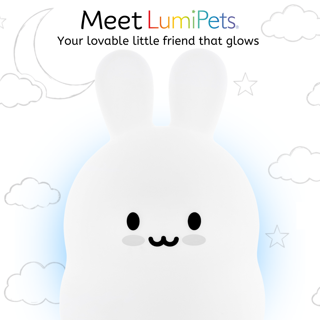 Baxter the Bunny Silicone Night Light is a glowing white silicone bunny with a happy facial expression, set against a background of simple line drawings of clouds, a crescent moon, and stars.
