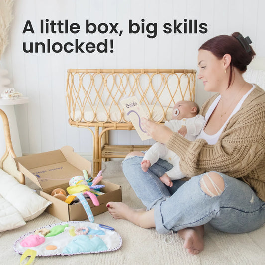 A woman sits on the floor holding a baby and reading a booklet. Nearby, an open box of Tiny Land® Montessori Toys for Newborns (0–3 Months) awaits. Text: A little box, big skills unlocked! The room is bright with woven furniture.
