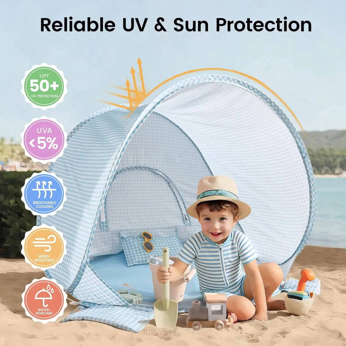 A child sits in a light blue gingham Kids Beach Tent & Sand Toy Set on the sand, holding a toy shovel next to a sand toy set, with icons showing UV, wind, and water protection features.